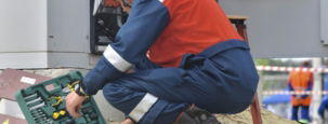 man in red and black jacket wearing black pants and red helmet holding green and black