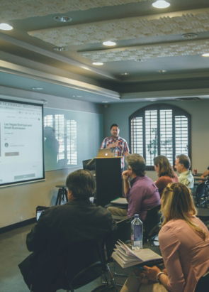 a-group-of-people-in-a-room-with-a-projector-screen.jpg a group of people in a room with a projector screen